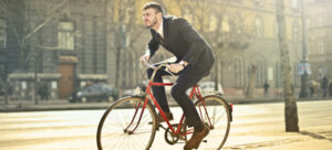 A man in a business suit riding bike while surviving the Vegas traffic 