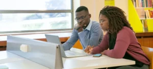 A man and a woman looking at their laptop and taking notes about how to choose the right movers when moving to North Las Vegas