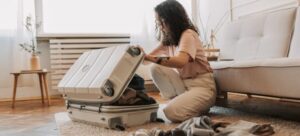 A young woman packing her bag for the move